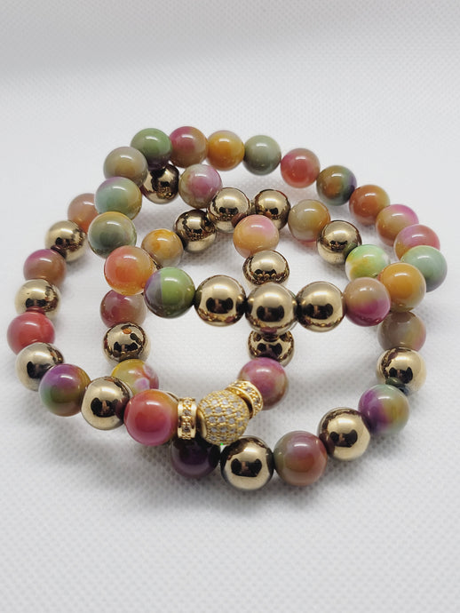 Set of colorful beaded bracelets with gold accents on a white background