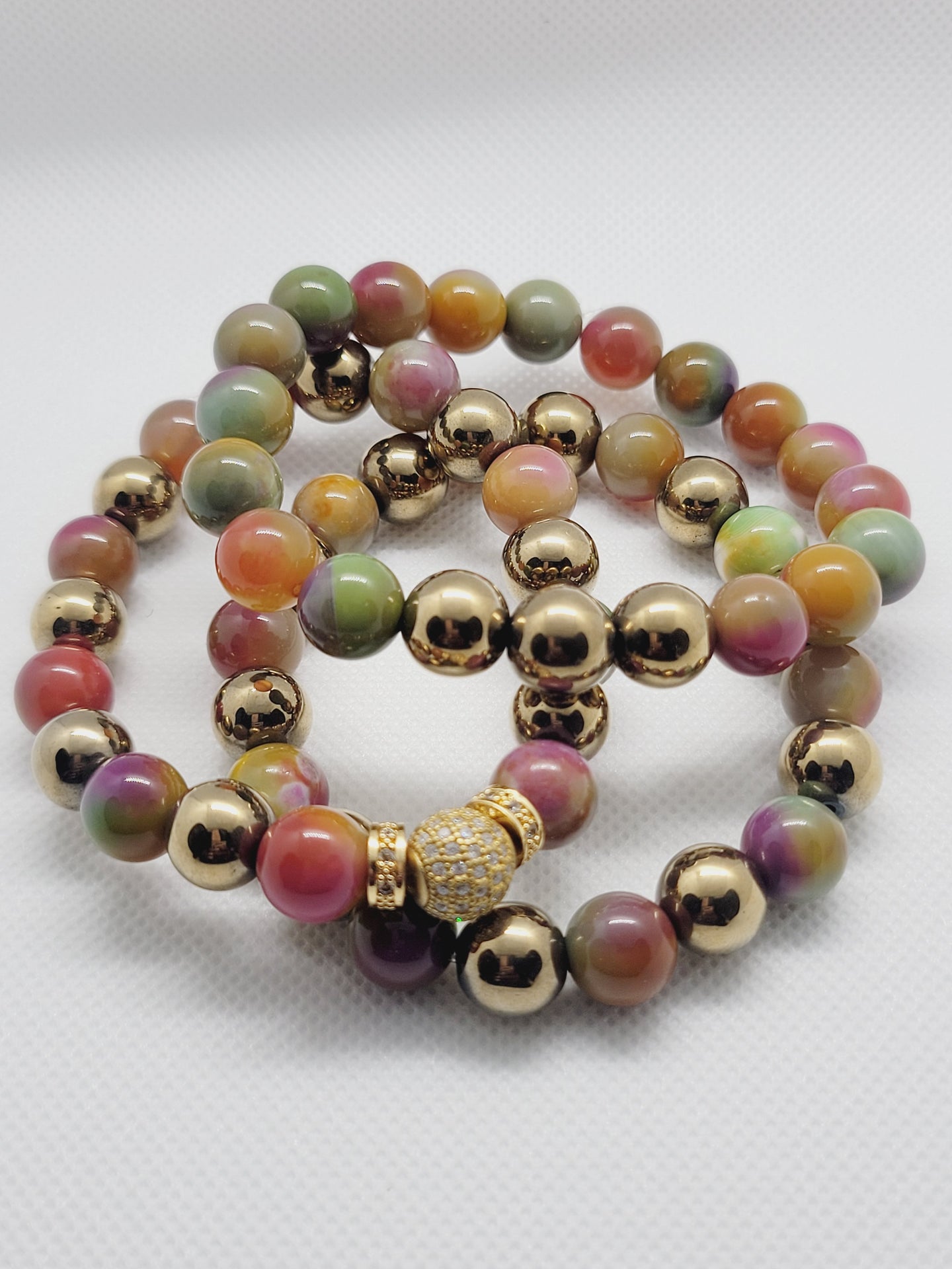 Set of colorful beaded bracelets with gold accents on a white background